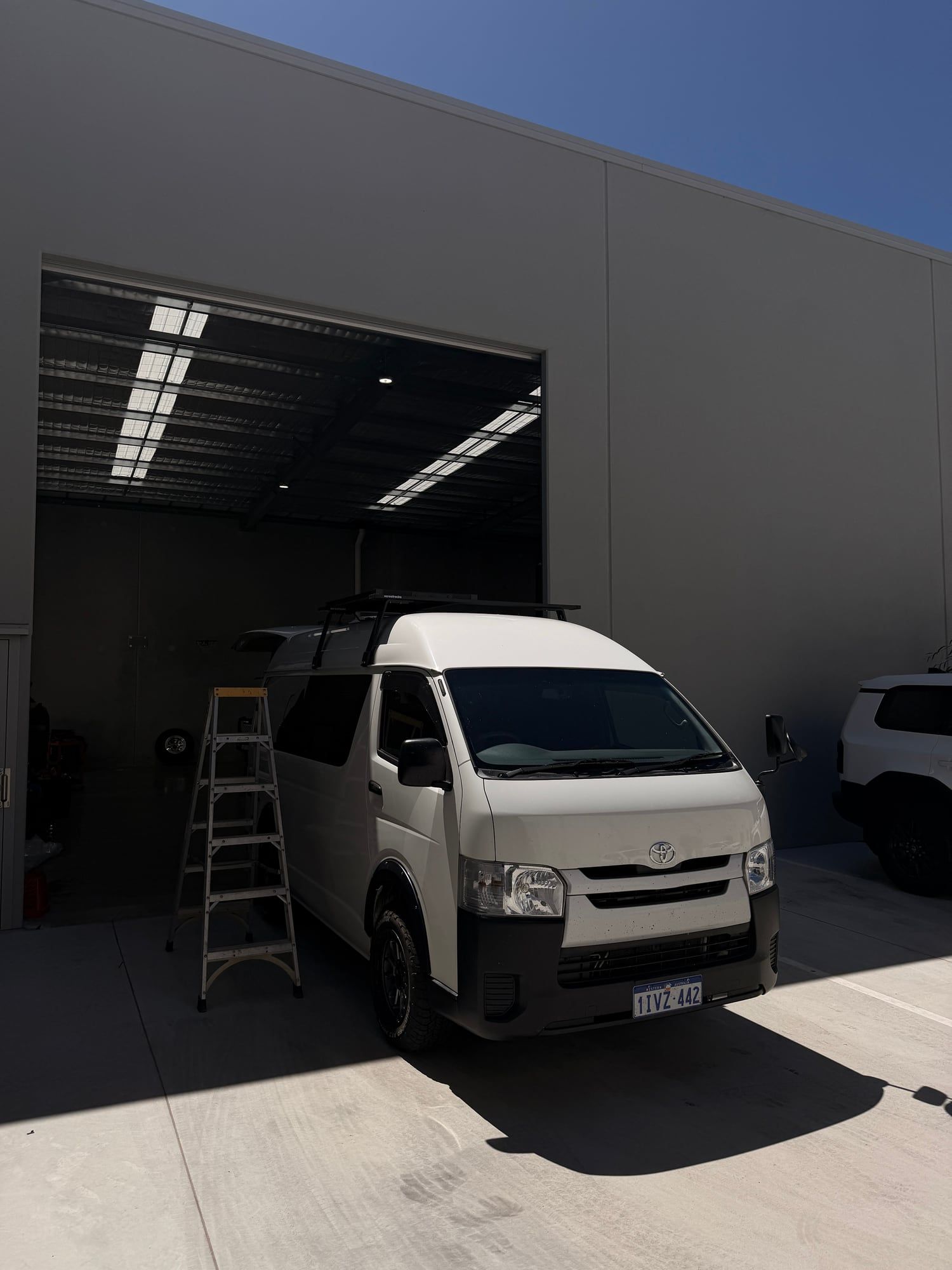 Short wheelbase Toyota HiAce outside the RAEG workshop after a dual battery and solar install