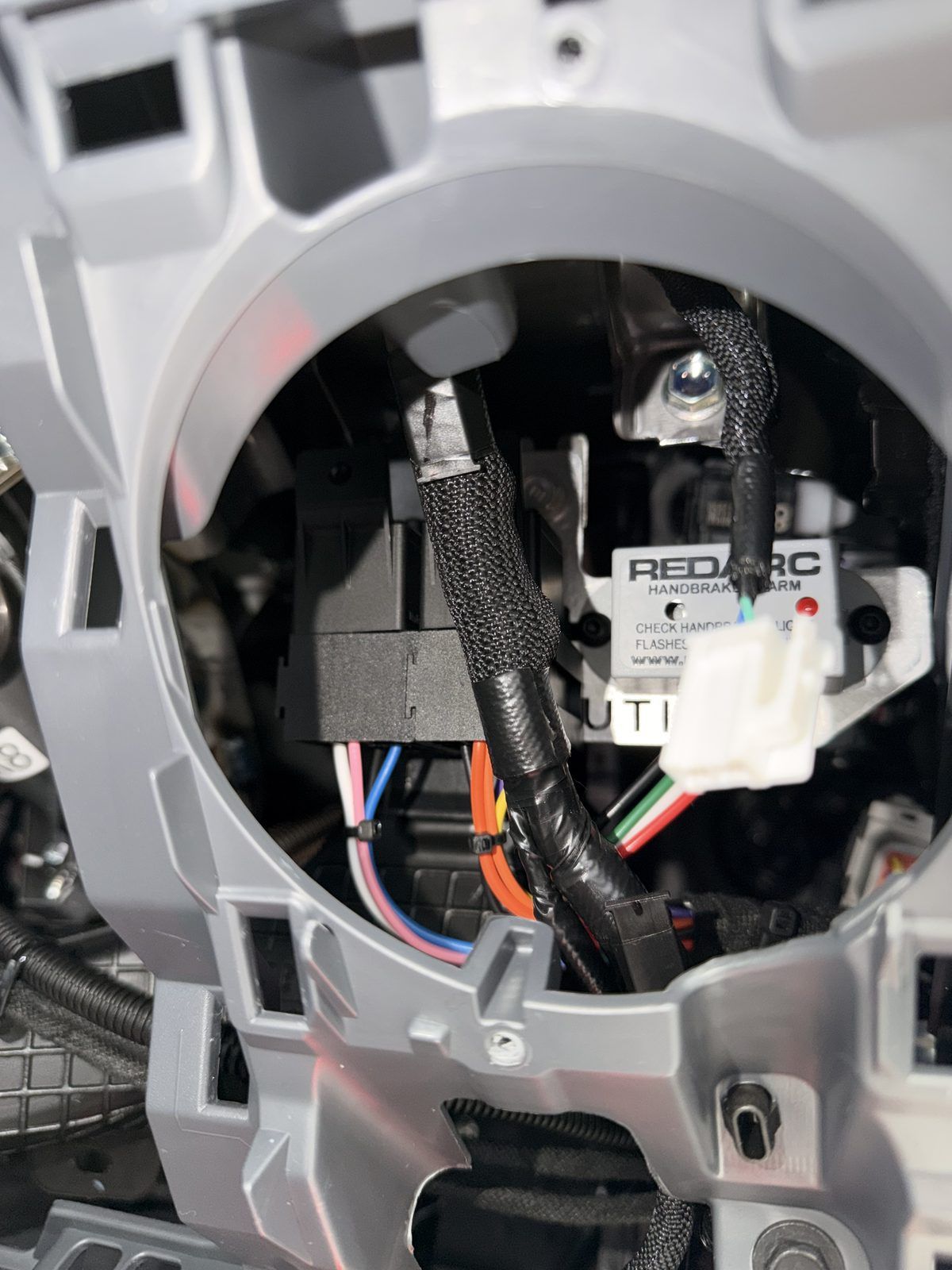 REDARC handbrake alarm installed behind the dash of a Hino