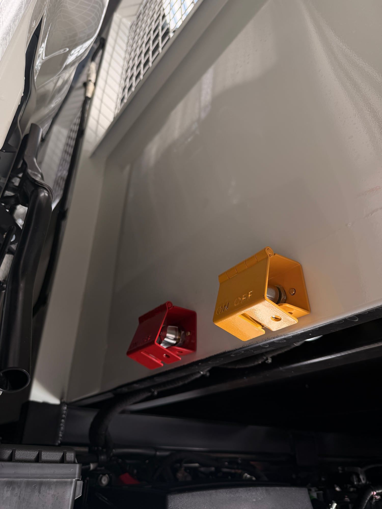 Red and yellow isolator switches mounted under a Hino tray