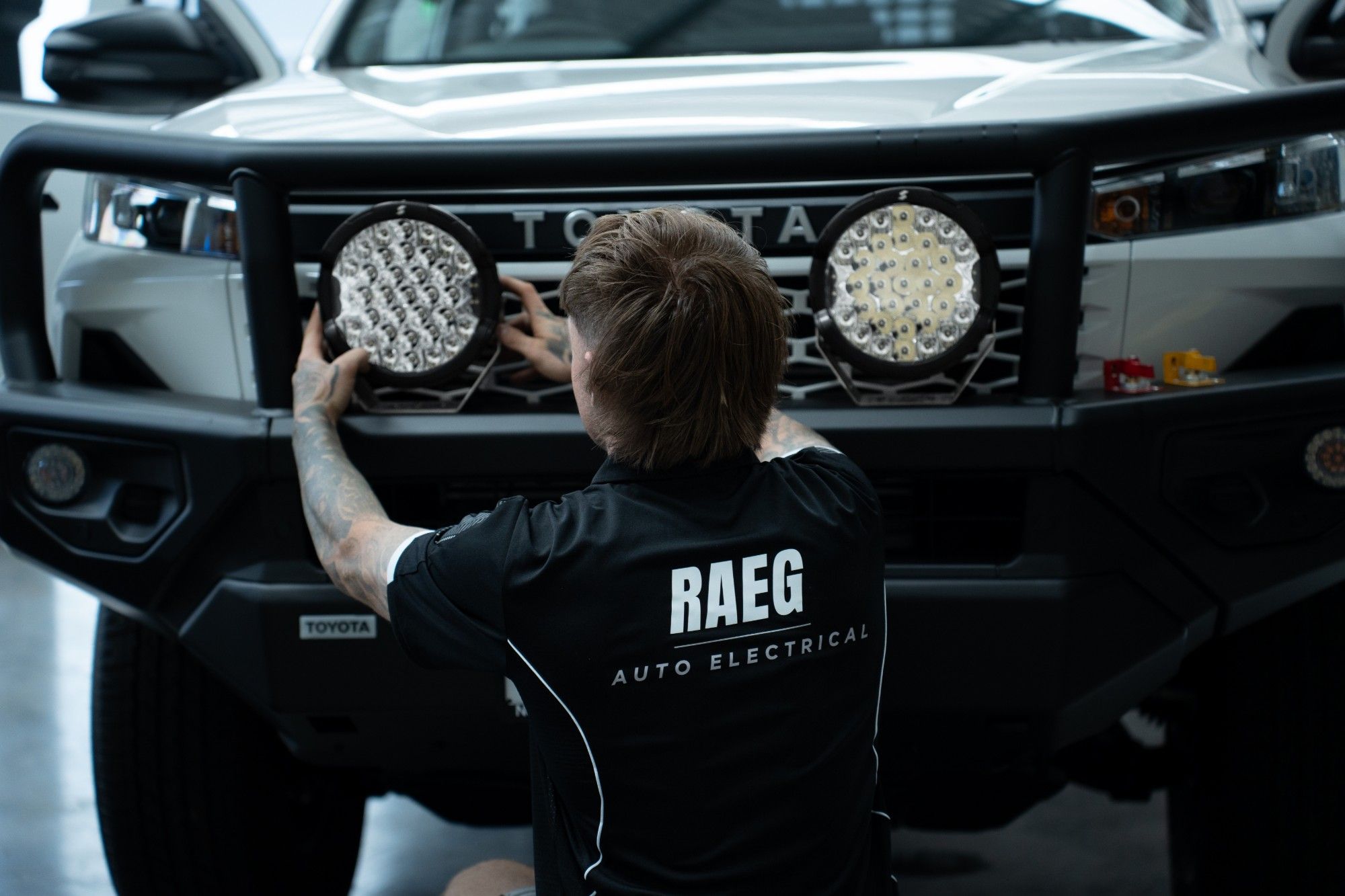 RAEG technician fitting driving lights to a bullbar